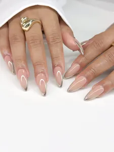 Macro detail of nude stiletto press-on nails with shiny silver metallic French tips