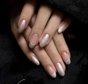 Detail view of almond shape press-on nails with silver pearlescent finish and white French tips