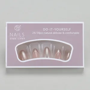 Detail view of oval French gold tip press-on nails set in elegant purple packaging box