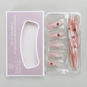 Detail view of almond press-on nails with red stars and dots in retail packaging
