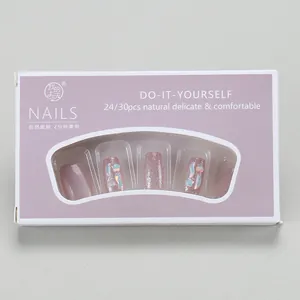 Detail view of purple cat-eye press-on nails with glitter and star patterns in a gift box