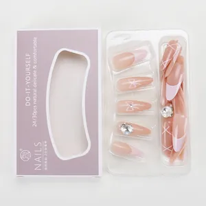 Dettaglio di unghie finte rosa con strass e decorazioni a fiocco stile francese