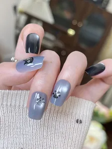 Détail de faux ongles œil-de-chat bleus avec motifs mignons de chats noirs et de pattes
