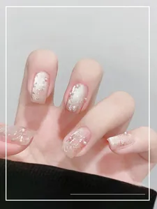 Détail macro d'ongles œil-de-chat avec perles et feuille d'or en ton rose doux