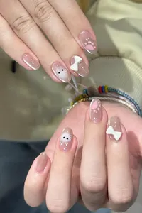 Détail de faux ongles œil-de-chat avec nœuds 3D et motifs de chatons mignons et doux