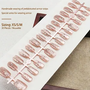 Faux ongles faits main œil de chat rose nude avec motifs argentés et perles chic