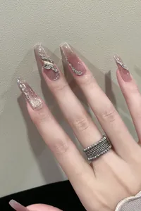 Detailed view of long coffin cat-eye gradient nails with rhinestones and silver 3D relief