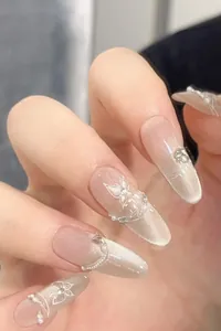 Macro detail of almond press-on nails with cat-eye effect and pearl butterfly design