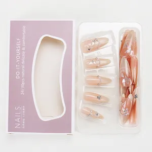 Detail of pink cat-eye press-on nails with 3D butterfly, pearl chains and rhinestones