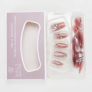 Detail view of pink cat eye press-on nails set with rhinestones and elegant packaging