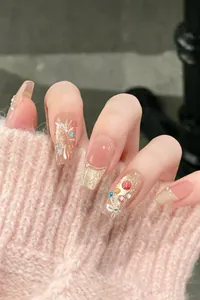 Detail of pink press-on nails with cat-eye rhinestones and glitter in coffin shape