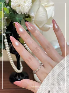 Detailed view of long almond ombre pink press-on nails with a soft pearl luster finish