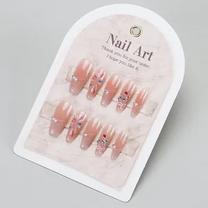 Pink gradient press-on nails with fireworks design and rhinestones on a display card