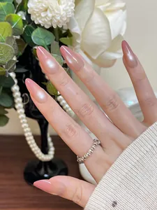 Detail of pink cat-eye press-on nails with almond shape and silver ring decoration
