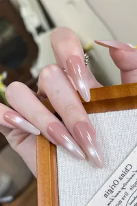 Detailed close-up of glossy pink ombre stiletto press-on nails with a smooth finish