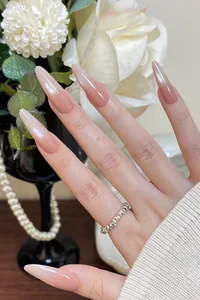 Macro detail of nude pink cat-eye almond press-on nails with pearl shimmer finish