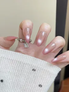 Macro view of almond press-on nails with pink cat-eye gradient and pearly shimmer