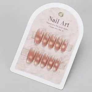 Handmade brown cat eye press-on nails set with elegant gradient on marble display
