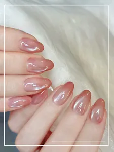 Close-up of nude pink gradient cat-eye press-on nails on elegant white satin background