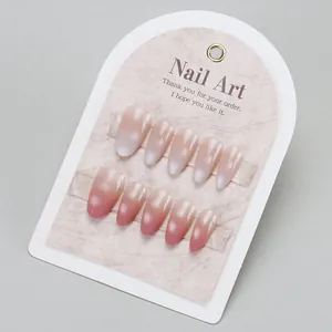 Detail of almond-shaped gradient pink press-on nails on marble backing card