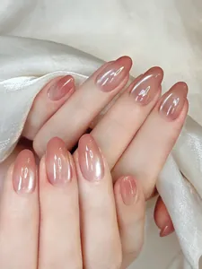 Detail of almond-shaped ombre pink press-on nails with aurora pearl finish on silk