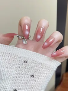 Macro shot of long almond cat-eye press-on nails with pink gradient and shimmer effect