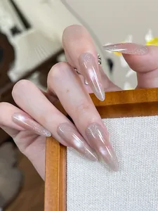 Detail of long almond press-on nails with pink gradient cat-eye shimmer and ink art