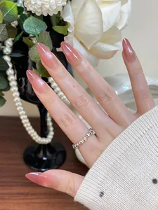 Detailed view of pink gradient almond press-on nails with aurora shimmer and silver ring