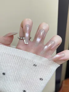 Detailed view of long almond press-on nails with pink glitter gradient and cat-eye finish
