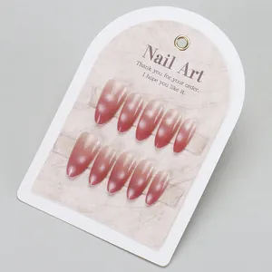 Detailed close-up of almond-shaped cat-eye press-on nails with pink gradient effect