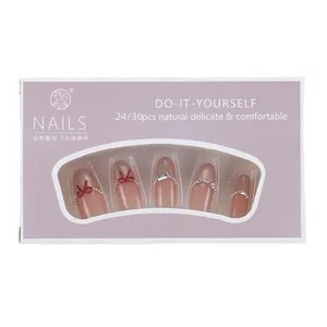 Handmade cat-eye press-on nails in nude pink with pearl beads and red bow decorations
