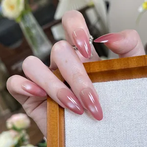 Reddish-brown cat-eye almond press-on nails with high gloss finish on hand