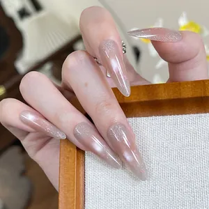 Long stiletto press-on nails with nude gradient, pink hearts and aurora glitter finish