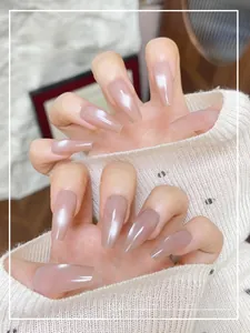 Detailed view of nude cat-eye press-on nails in long coffin shape on hands