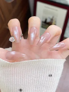 Macro detail of long coffin press-on nails in nude cat eye finish on hand