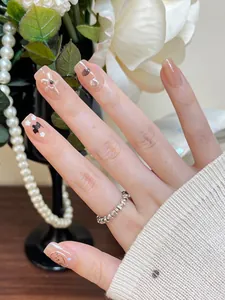 Dettaglio di unghie press-on fatte a mano con decoro orsetto e stella marina
