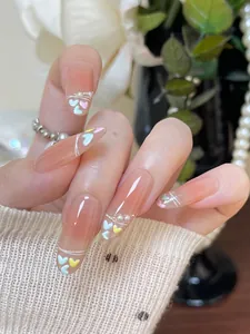 Detailed view of handmade almond press-on nails with pastel heart patterns and pearls
