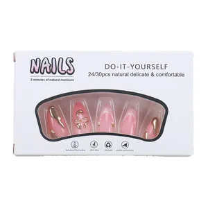Pink French press-on nails with gold chrome accents and marble texture in a white box