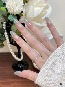 Nahaufnahme langer Mandel-Nägel mit rosa-grünem Katzenaugen-Glitzer-Farbverlauf