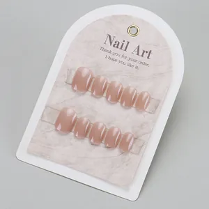 Short square press-on nails in nude pink color with glossy finish on marble display