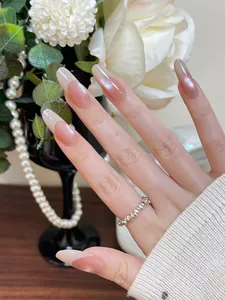 Close-up of elegant long almond cat-eye press-on nails with pearl luster and gradient pink