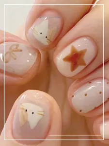 Macro detail of wearable nail art featuring cute hand-painted cats, stars, and bows