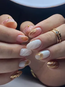 Detailed view of handmade press-on nails with 3D shell texture, gold accents and pearls