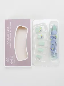 Vista detallada de uñas postizas macaron con diseños floraux y textura de gota en 3D