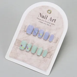 Uñas postizas cortas macaron con gotas de agua 3D y diseño floral mate