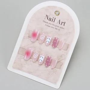 Detalle de uñas postizas hechas a mano con degradado rosa y diseños de búho