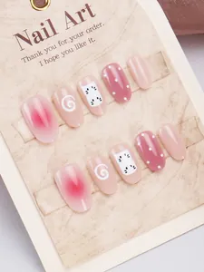 Detalle de uñas postizas artesanales con gatos rosas y diseños de degradado blush suaves
