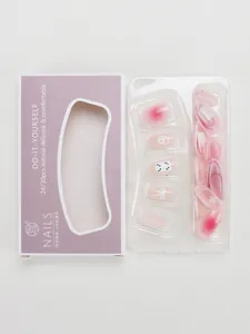 Detalle de uñas postizas rosas con motivos de gato, lazos 3D y arte degradado