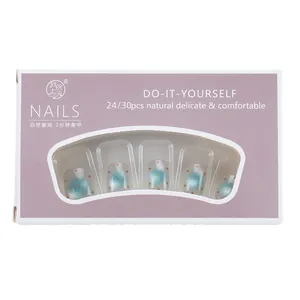 Faux ongles courts bleus à pois rouges dans leur boîte cadeau violette à fenêtre