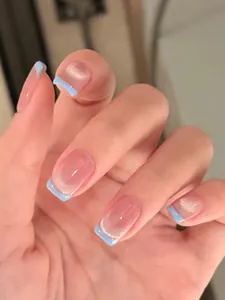 Detailed close-up of French blue tip cat eye press-on nails with natural nude base